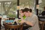 A male sitting at a table in Starbucks on campus.