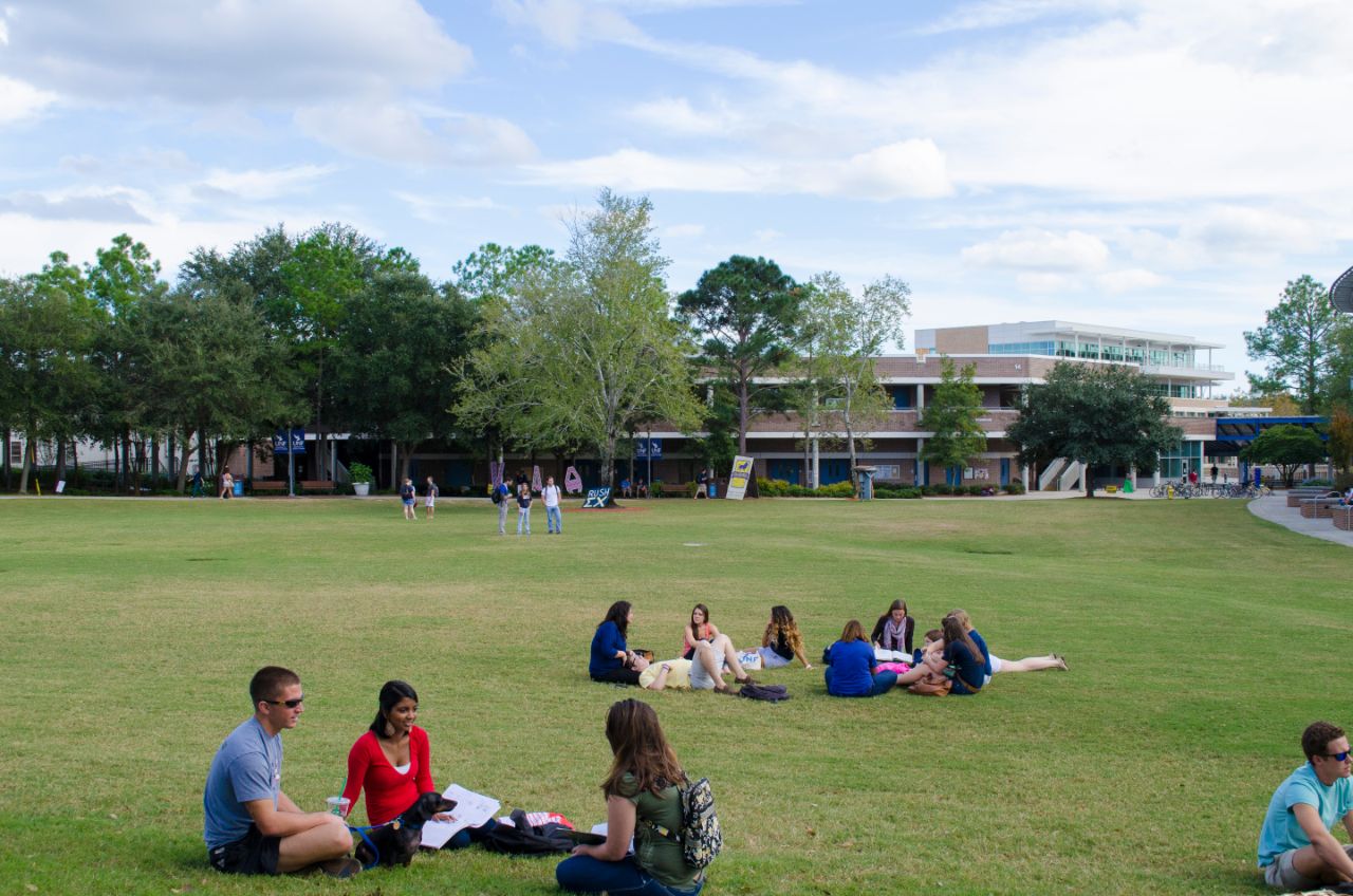 Several groups of students sitting and standing around the Green.