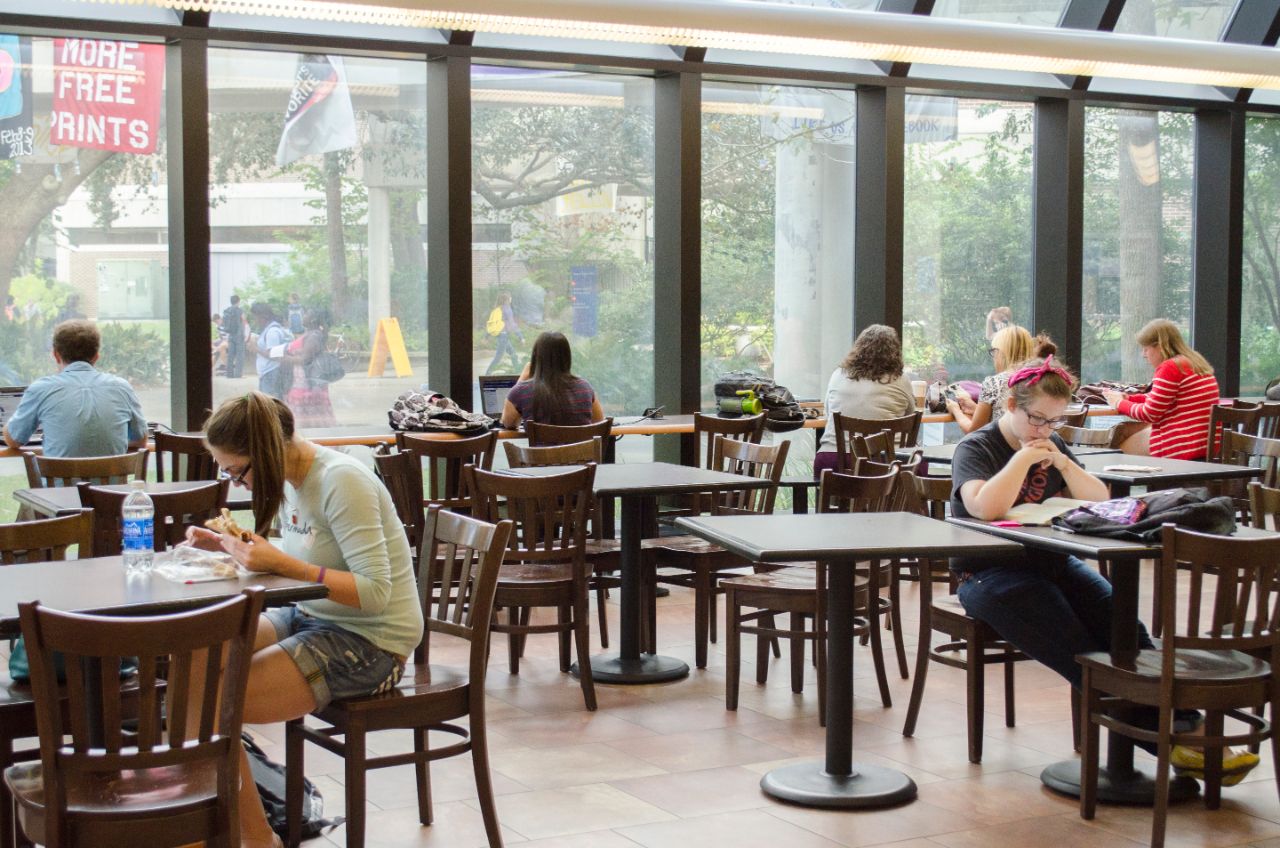 Students sitting at various tables studying and eating.