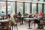 Students sitting at various tables studying and eating.