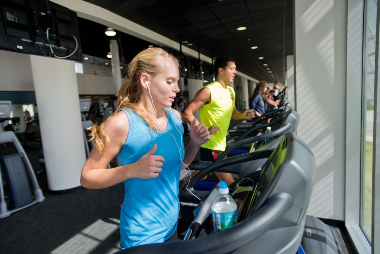 A line of people running on treadmills.