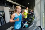 A line of people running on treadmills.