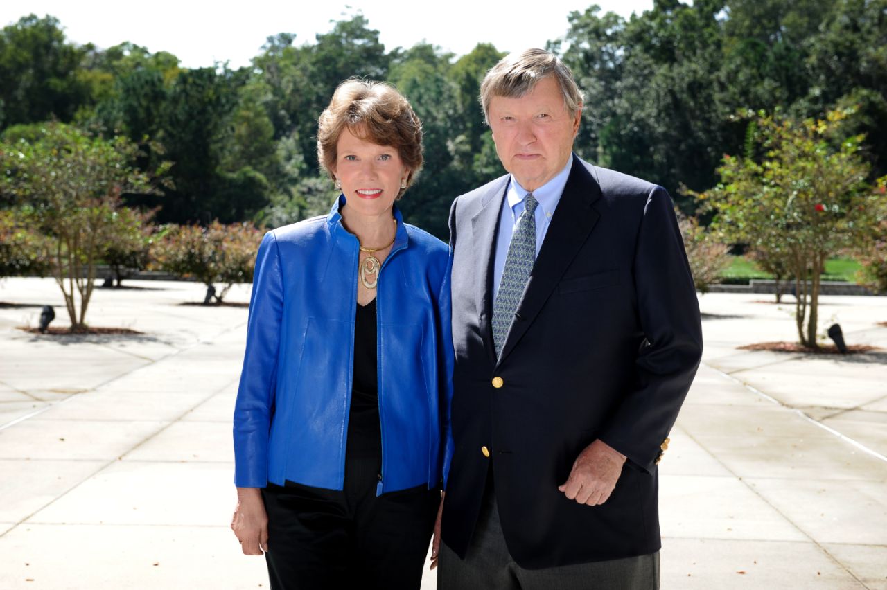 A female and a male standing in a courtyard at Hicks Hall.